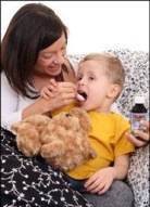 Mother giving child Olbas Cough Syrup